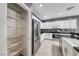Pantry and kitchen featuring white cabinets, stainless steel appliances, and black countertops at 2154 Idaho Falls Dr, Henderson, NV 89044