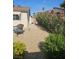 Charming backyard featuring gravel, flowering bushes, a chair, and a view of the home's exterior at 308 Sunbeam Dr, Las Vegas, NV 89107