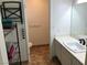 Well-lit bathroom with a single sink vanity and a neatly organized shelving unit for storage at 308 Sunbeam Dr, Las Vegas, NV 89107