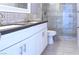Bathroom with dual sinks and sleek cabinets alongside a glass-enclosed shower at 3412 Adventure Ct, Las Vegas, NV 89129