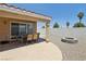 Backyard featuring a covered patio, outdoor dining area, and stone fire pit with low-maintenance landscaping at 3538 Canter Dr, North Las Vegas, NV 89032