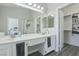 Double sink bathroom with white counters, large mirror, gray floors, and a step in shower at 3538 Canter Dr, North Las Vegas, NV 89032