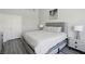 Clean bedroom with gray headboard, white bedding, gray wood floors, and closet with a sliding door at 3538 Canter Dr, North Las Vegas, NV 89032