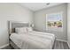 Bedroom with a light gray headboard, gray wood floors, a large window, and ample space at 3538 Canter Dr, North Las Vegas, NV 89032
