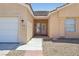 Welcoming facade highlighting the front door, tidy desert landscaping, and a spacious two-car garage on the side at 3538 Canter Dr, North Las Vegas, NV 89032