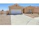 Single-level home featuring a neutral color scheme, tiled roof, desert landscaping, and an attached two-car garage at 3538 Canter Dr, North Las Vegas, NV 89032