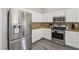 The kitchen features a stainless steel fridge, stove, and white cabinetry at 3538 Canter Dr, North Las Vegas, NV 89032