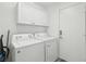 Functional laundry room with front load washer and dryer set and overhead cabinets for storage at 3538 Canter Dr, North Las Vegas, NV 89032
