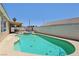 Backyard pool area with a hot tub, covered patio, and serene privacy wall at 3538 Canter Dr, North Las Vegas, NV 89032