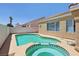Backyard pool and spa with tile trim, complemented by a stucco privacy wall and landscaping at 3538 Canter Dr, North Las Vegas, NV 89032