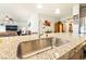 Modern kitchen with granite countertops, stainless steel sink, and open layout to the living area at 357 S Milan St, Henderson, NV 89015