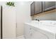 Efficient laundry area with storage cabinets and a modern, white washer and dryer at 357 S Milan St, Henderson, NV 89015