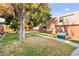Exterior shot featuring a grassy backyard with mature tree shading the residential complex at 3668 Villa Knolls East Dr, Las Vegas, NV 89120
