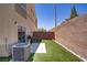 Spacious backyard featuring artificial grass, a patio, and an AC unit at 4020 Smokey Fog Ave # 3, North Las Vegas, NV 89081