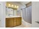 Bathroom with double sinks, wood cabinets, tile flooring, and a shower with gray tile at 4020 Smokey Fog Ave # 3, North Las Vegas, NV 89081