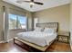Cozy bedroom features a large window, neutral walls, fan and wood laminate floors at 4020 Smokey Fog Ave # 3, North Las Vegas, NV 89081