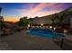 Evening backyard showcasing a pool, patio area, waterfall feature, and vibrant sky at 4435 Peaceful Harbor St, Las Vegas, NV 89129