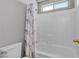 Small bathroom featuring white-tiled shower and bathtub area and matching gray shower curtain at 4435 Peaceful Harbor St, Las Vegas, NV 89129