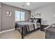 Comfortable bedroom with neutral walls, carpet flooring, and window overlooking a black bed set at 4435 Peaceful Harbor St, Las Vegas, NV 89129