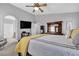 Bright bedroom featuring a ceiling fan, TV, and wooden dresser and mirror at 4435 Peaceful Harbor St, Las Vegas, NV 89129