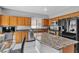 Open kitchen with breakfast bar, wood cabinets, granite countertops and stainless appliances at 4435 Peaceful Harbor St, Las Vegas, NV 89129