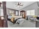 Well decorated primary bedroom features large windows, chair, ceiling fan, and a gorgeous bed set at 4435 Peaceful Harbor St, Las Vegas, NV 89129