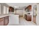 A kitchen area with dark wooden cabinets and views into other rooms at 4612 Standing Bluff Way, Las Vegas, NV 89130
