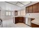 Bright kitchen with dark wooden cabinets, stainless steel appliances, and white tile floors at 4612 Standing Bluff Way, Las Vegas, NV 89130