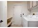 Functional laundry room featuring a washer, dryer, shelving, and convenient access door at 4612 Standing Bluff Way, Las Vegas, NV 89130