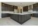 Spacious kitchen with dark cabinetry, a large center island with white countertop, and stainless steel appliances at 4630 Blushing Dawn Ave, Las Vegas, NV 89118