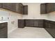 Functional laundry room boasting dark wood cabinets, white countertops, and tile flooring at 4630 Blushing Dawn Ave, Las Vegas, NV 89118