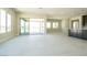 Open-concept living space with tile flooring, access to an outdoor patio, and an adjacent kitchen area at 4630 Blushing Dawn Ave, Las Vegas, NV 89118