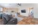 Open-concept living room with tile flooring, ceiling fan, and seamless flow to dining area and kitchen at 4837 River Splash Ave, Las Vegas, NV 89131