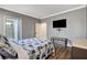 Bedroom features gray walls, wood-look floors, ensuite bathroom, and a mounted TV at 5516 Tantalum Ln, Las Vegas, NV 89122