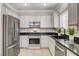 Kitchen featuring stainless steel appliances, white cabinetry, and tile flooring at 5516 Tantalum Ln, Las Vegas, NV 89122