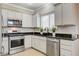 The kitchen features white cabinets, stainless steel appliances, and black granite countertops at 5516 Tantalum Ln, Las Vegas, NV 89122
