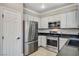 Kitchen featuring stainless steel appliances, white cabinetry, and granite countertops at 5516 Tantalum Ln, Las Vegas, NV 89122