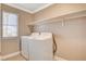 Bright laundry area featuring a washer, dryer, and convenient overhead shelving for optimal storage solutions at 5516 Tantalum Ln, Las Vegas, NV 89122