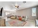 Open-concept living room with tiled floors, ceiling fan, neutral decor, and an adjacent dining area at 5516 Tantalum Ln, Las Vegas, NV 89122