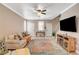 Inviting living room featuring neutral tones, tile flooring, ceiling fan, and a comfortable seating arrangement at 5516 Tantalum Ln, Las Vegas, NV 89122