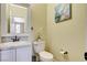 This powder room boasts white cabinets, granite countertop, framed mirror, and a convenient toilet paper holder at 5516 Tantalum Ln, Las Vegas, NV 89122