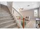 Carpeted staircase with white railings leads to the living room boasting tile flooring and a comfortable sitting area at 5516 Tantalum Ln, Las Vegas, NV 89122