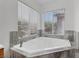 Relaxing bathroom featuring a tile-surrounded tub with dual windows at 575 Aspen Leaf St, Las Vegas, NV 89144