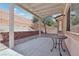 Covered patio with landscaping and tiered block wall in backyard at 575 Aspen Leaf St, Las Vegas, NV 89144