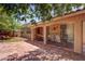 Outdoor living area featuring covered patio, stone flooring, garden beds, and mature trees at 5896 Shining Moon Ct, Las Vegas, NV 89131