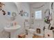 Charming bathroom with pedestal sink, stylish decor, and a bright window at 5896 Shining Moon Ct, Las Vegas, NV 89131