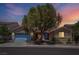 Charming single-story home with mature tree, blue garage door, and beautiful sunset sky at 5896 Shining Moon Ct, Las Vegas, NV 89131
