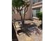 Cozy backyard featuring a seating area with a small tree for shade and a minimalist stone landscape at 59 Belle Maison Ave, Las Vegas, NV 89123
