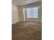 Bright bedroom featuring a window, neutral paint, and brown carpet at 59 Belle Maison Ave, Las Vegas, NV 89123