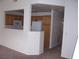 Functional kitchen featuring a breakfast bar, white appliances, and natural wood cabinets at 59 Belle Maison Ave, Las Vegas, NV 89123